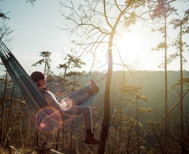 Man relaxing in hammock in rural setting to promote Fatigue management for agency nurses