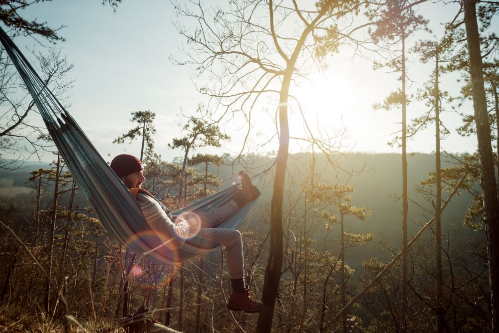 Man relaxing in hammock in rural setting to promote Fatigue management for agency nurses